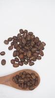 Top View of Coffee Beans on Wooden Spoon on White Background photo