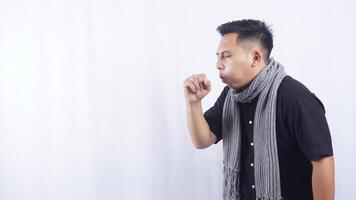 Side View of Young Asian Man Coughs Into His Hand on White Background photo