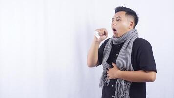 Young Asian Man with Scarf Suffering from Chronic Cough on White Background photo