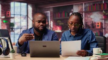African american people at home entering card digits to renew an account subscription, managing streaming services on laptop. Couple transferring money, updating the credentials. Camera B. video