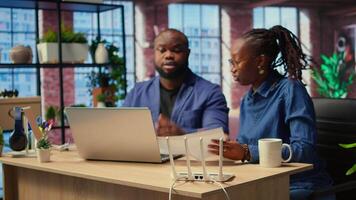 Discouraged African American couple struggles with an unstable Wi Fi network, getting angry while they are troubleshooting to fix the error. Stressed people with lots of remote tasks. Camera A. video
