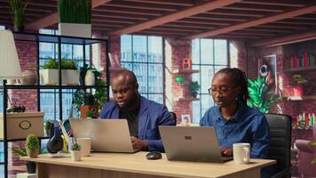African American people at home office analyzes online business trends, using teamwork and technology to manage their freelance careers and boost tasks efficiency. Networking. Camera A. video