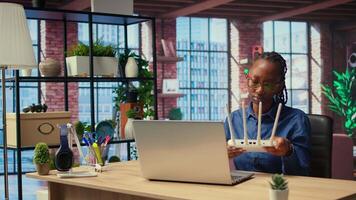 African American woman rebooting the wi fi modem by pulling out cables, checking with the internet provider for support. Troubleshooting ongoing Wi Fi connectivity issues. Camera A. video