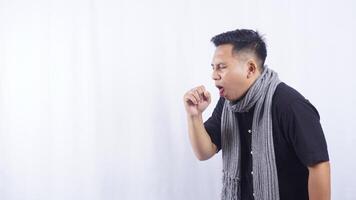 Side View of Young Asian Man with Coughs Into His Hand on White Background photo