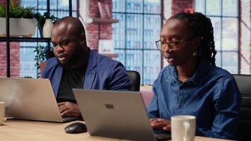 African American people at home office analyzes online business trends, using teamwork and technology to manage their freelance careers and boost tasks efficiency. Networking. Camera B. video