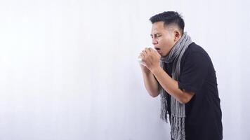 Portrait of Young Asian Man with Scarf Suffering from Acute Cough on White Background photo