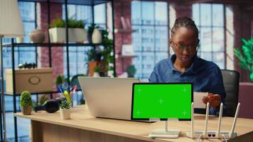 African American female freelancer browse troubleshooting guide next to copy space, working on debugging router issues to restore home network. Young woman struggles to solve tasks. Camera A. video