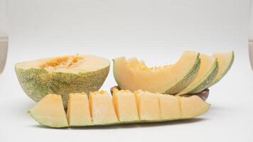 Half, Slices, and Pieces of Cantaloupe Melon with Selective Focus on White Background photo