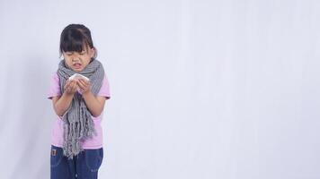 Asian Kid Girl with Scarf Going to Sneeze into Tissue Paper on White Background photo
