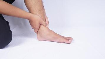 Man Suffering from Ankle Injury on White Background photo