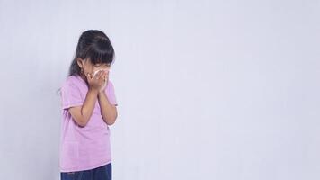 Asian Little Girl Blow Her Nose in Tissue Paper Suffering from Flu on White Background photo