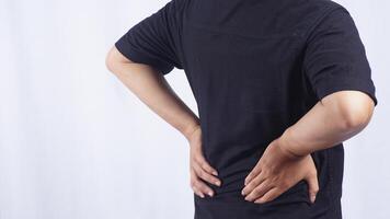 Close Up of Rear View of Young Man Suffering from Lower Back Pain on White Background photo