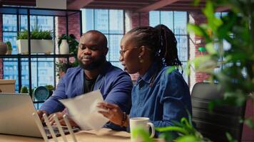 African American angry woman pulling out the LAN cable from the router while her partner reads a technical manual for troubleshooting. Couple getting mad and arguing over signal loss. Camera A. video