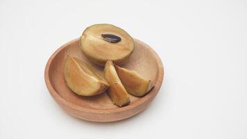 Half and Slices Sapodilla Fruit on Wooden Plate on White Background photo