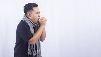 Portrait of Young Asian Man with Scarf Coughing on White Background photo