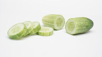 Fresh Half and Slices of Cucumber on White Background photo