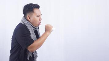 Young Asian Man with Scarf Suffering from Cough on White Background photo