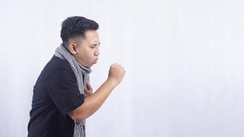 Side View of Unhealthy Young Asian Man Coughing on White Background photo