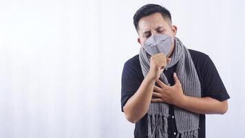 Young Man Wearing Mask Coughing on White Background photo