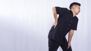 Asian Young Man Suffering from Lower Back Pain on White Background photo