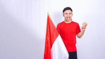 Portrait of Indonesian Man with Red and White Attribute Showing Yes Pose to Celebrate Independence Day of Indonesia on White Background photo