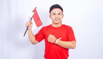 Indonesian Man Showing Salute Pose with Red and White Attribute on White Background photo