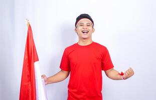 Portrait of Indonesian Man with Red and White Attribute Showing Happy Expression on White Background photo