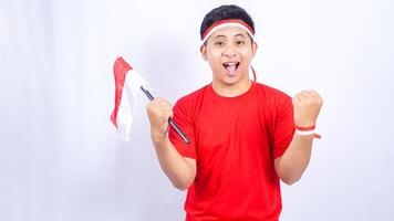 Excited Indonesian Man with Red and White Ribbons Showing Yes Gesture Celebrate Independence Day of Indonesia on White Background photo