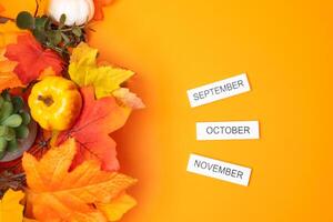 Blocks September, October, November and autumn yellow leaves. Concept of beginning of new fall season. Months of fall. Decoration flat lay photo