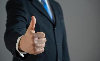 A businessman shows a thumbs up as a sign of approval and acceptance. Agreement satisfaction. Negotiation success. Professional recognition. Recruitment for work. photo
