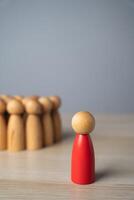 The red man stands away from the group, rejected and exiled. Social exclusion, rejection, workplace discrimination, loneliness, isolation, and being an outcast. Social pressure, and nonconformity. photo
