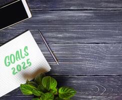 Notes with words Goals 2025 and pen with phone. Motivation, inspiration. Planning, plans and tasks. New business ideas. Setting goal photo