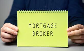 Mortgage broker concept. A licensed intermediary who connects borrowers with lenders by offering expert advice and assistance tailored to the borrower's financial needs. Note in male hands photo