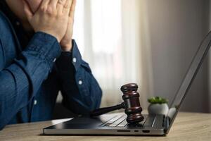 Frustrated man and court gavel on laptop. Laws and regulations. Restrictions and blocking of resources. Restrictions on access to the Internet. Internet earnings, regulation. Censorship photo