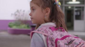 Schoolgirl with backpack walking outside school after classes video