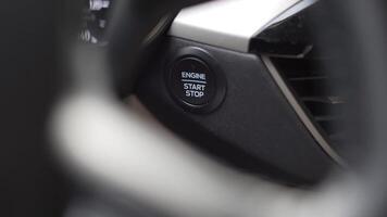 Close up of start stop button on car steering wheel flashing green light in slow motion. video