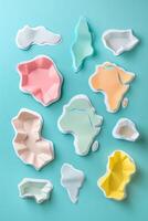 Colorful abstract shapes resembling continents arranged on a turquoise background for creative use photo