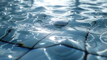 Close-up of shimmering water surface reflecting light, showcasing ripples and tile patterns photo
