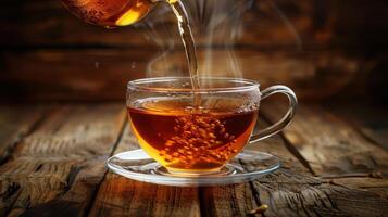 A steaming cup of tea being poured on a rustic wooden table, with warm lighting enhancing the scene photo