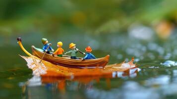 Miniature figures rowing a boat made of a leaf on a tranquil water surface, surrounded by greenery photo