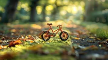 A small orange bicycle stands on a path covered with autumn leaves in a sunlit park photo