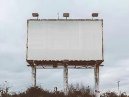 An old billboard sits in the middle of a field photo