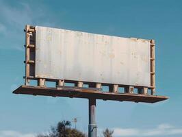 An old billboard on a pole in the middle of a field photo