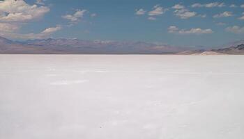 A man standing on a white plain with mountains in the background photo