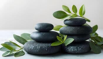 A stack of black stones with leaves on top photo
