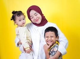 a woman with two children on a yellow background photo
