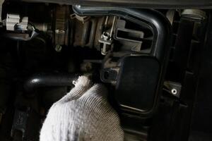 un mecánico inspeccionando el motor componentes de un vehículo para mantenimiento. foto