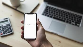 A hand holding a smartphone displaying an online tax filing app with a Submitted Successfully notification photo