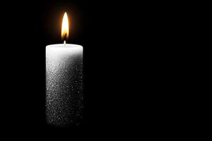 White candle with glitter gradient effect on black background photo