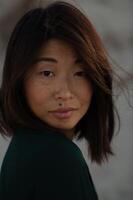 The suns last rays cast a gentle glow on an Asian womans face, highlighting her unique charm. photo
